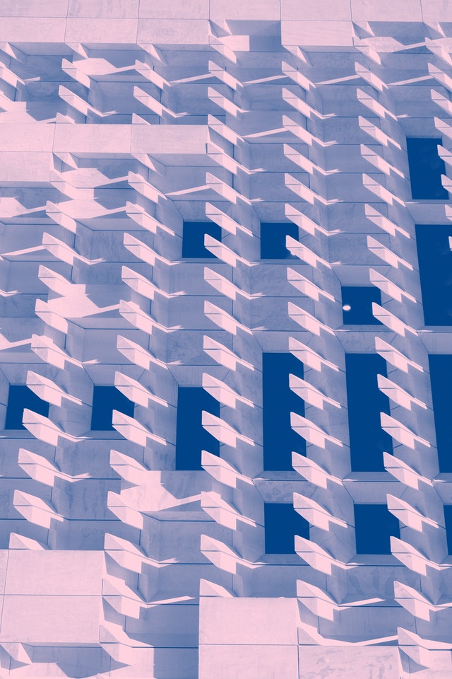 abstract image with a pastel pink background, navy rectangles of various sizes, and light blue overlay forming a repeated feathered pattern